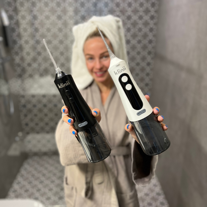 Woman holding white and black Klinii Water Flossers