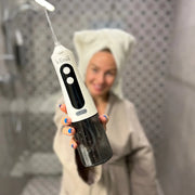 Woman holding the white Klinii Water Flosser
